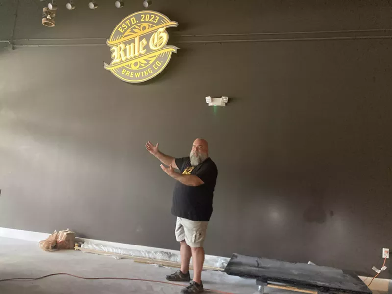 Image: Rule G Brewing Company owner Ralph Rapa shows off an illuminated sign of his brewery during construction in October 2023.