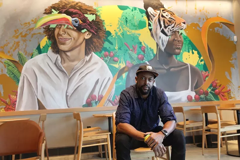 Image: Artist Nate Dee with the mural he painted inside the new Starbucks Community Store in Fort Lauderdale.