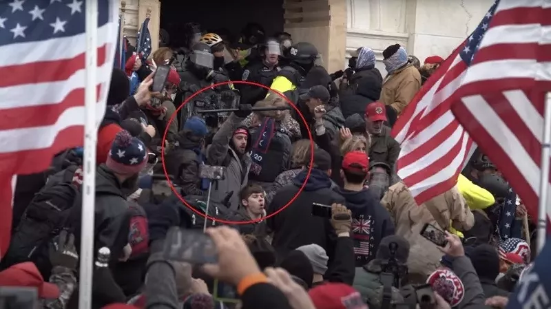 Image: Mason Courson raises a baton during the January 6, 2021, Capitol riot.