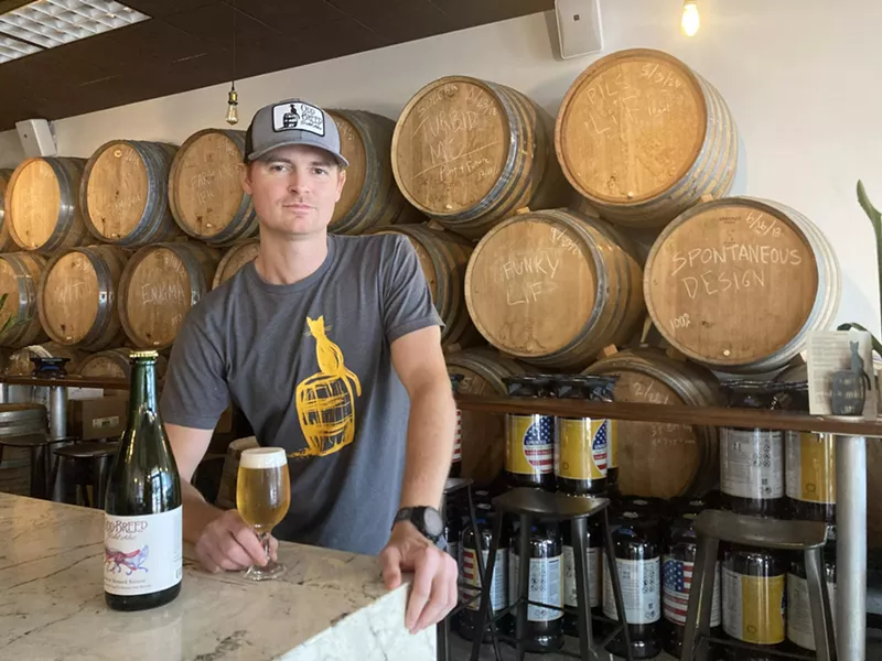 Image: Odd Breed Wild Ales' Matt Manthe with a glass of "Loup et Renard," a saison collaboration with 3 Sons Brewing Co. that won a gold medal at the 2023 Great American Beer Festival.