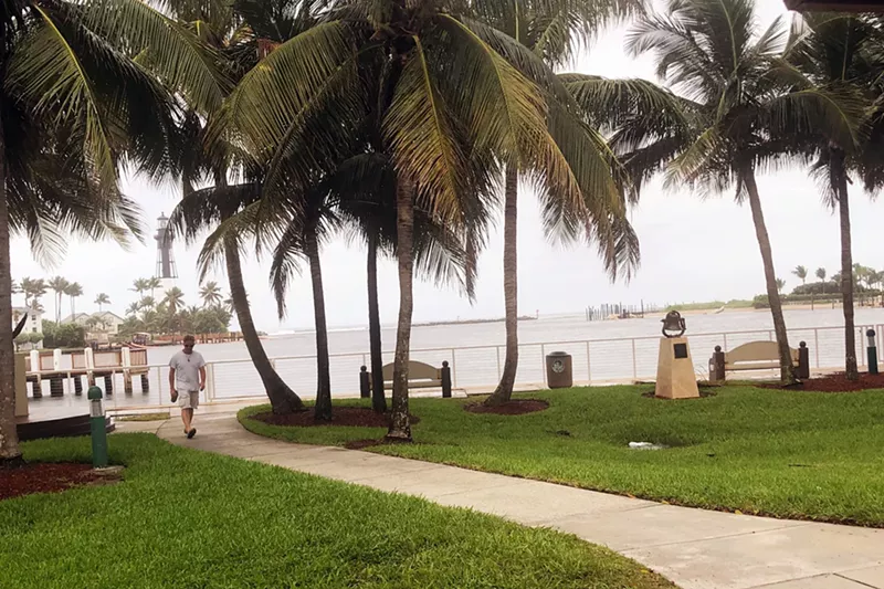 Image: A parkgoer risks the light rain and winds from Dorian at Hillsboro Inlet Park on Monday.