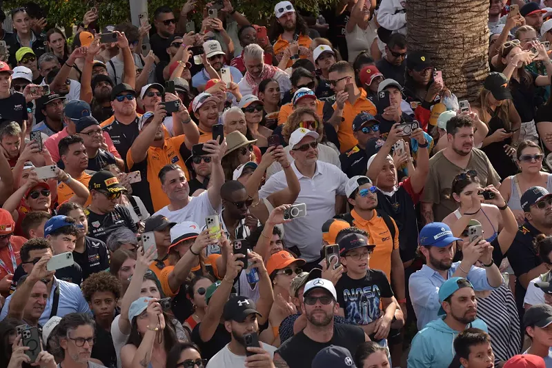 Image: crowd shot. a lot of people holding up their phones to capture the podium ceremony