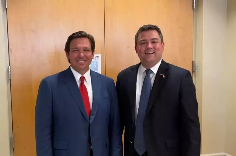 Image: Christian Ziegler (right) stands next to Florida Gov. Ron DeSantis at the Venice Community Center in Venice, Florida on February 10, 2021.